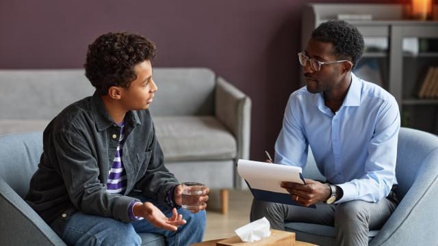 young man speaking to a counselor in an office setting