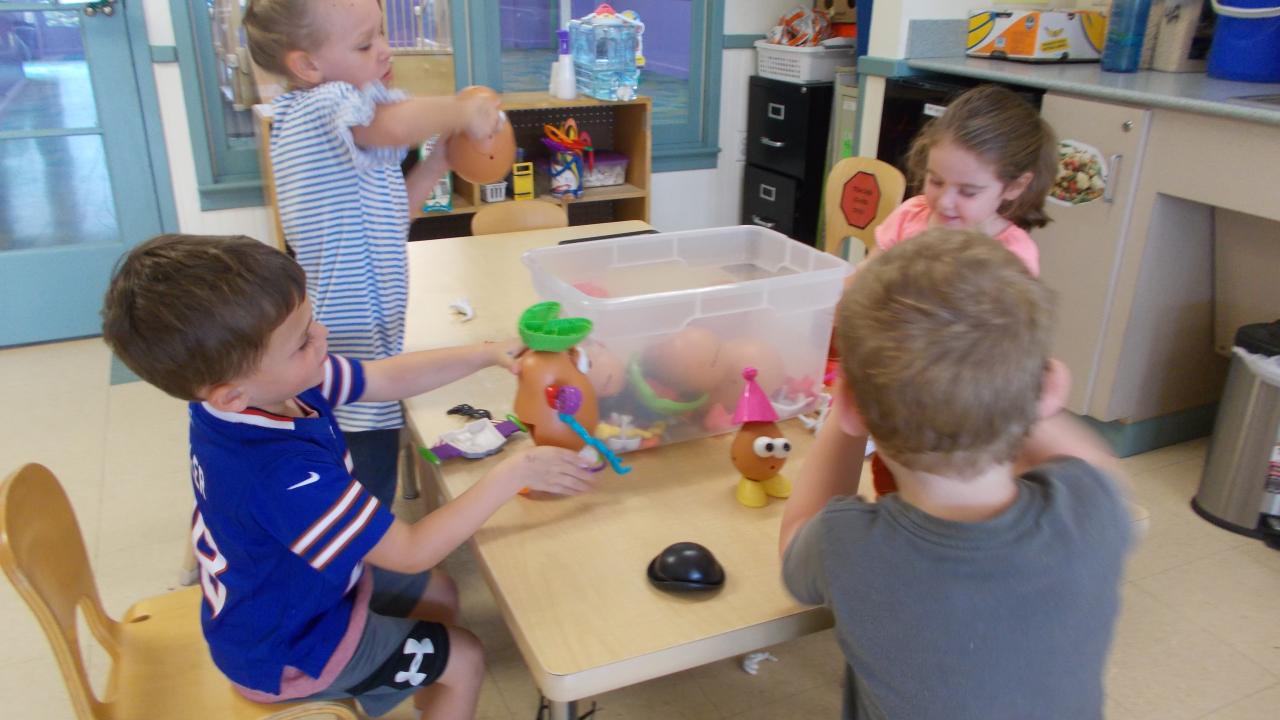Children playing at a table in a classroom
