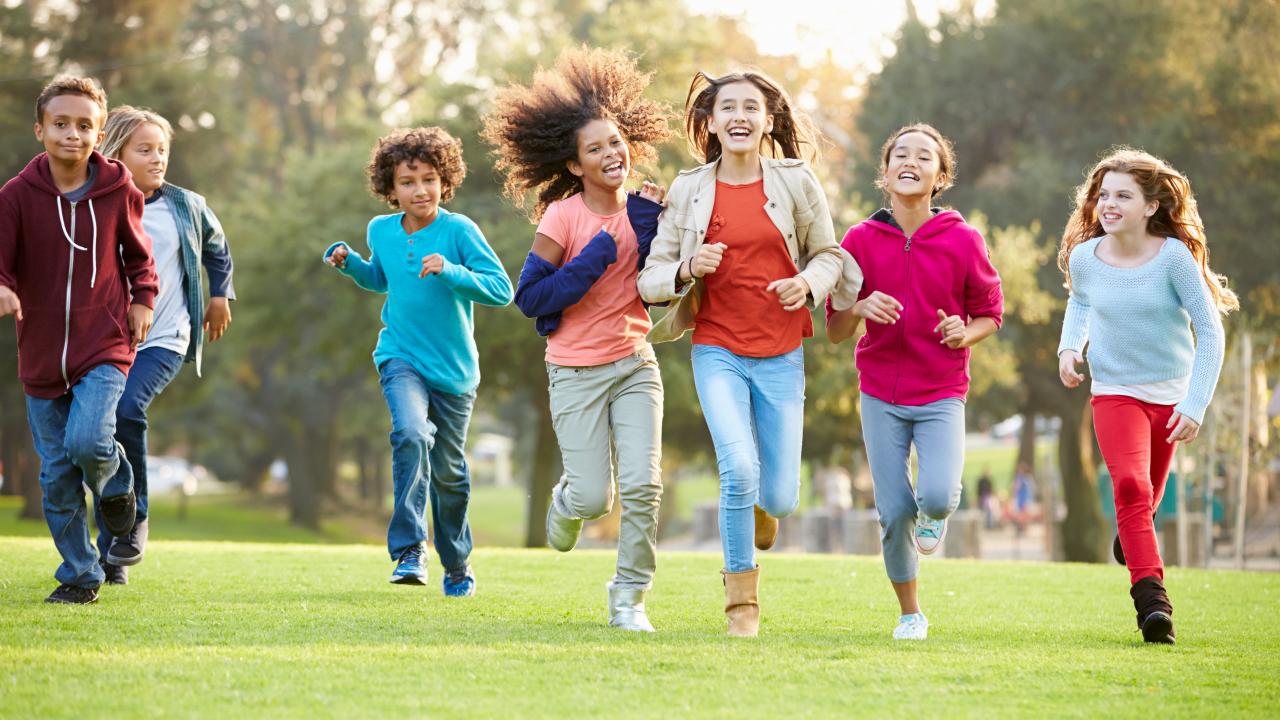 Happy children running through a park