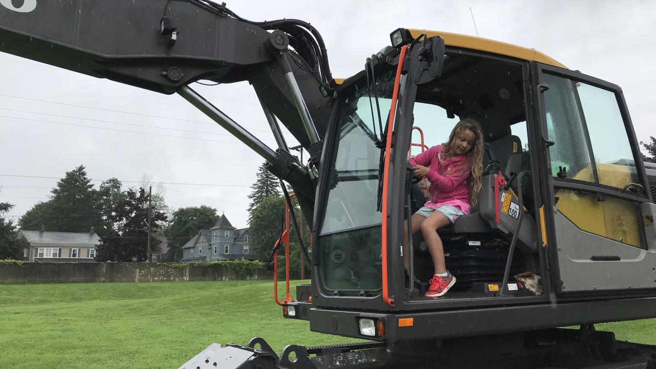 Little girl sitting in the cab of a frontloader