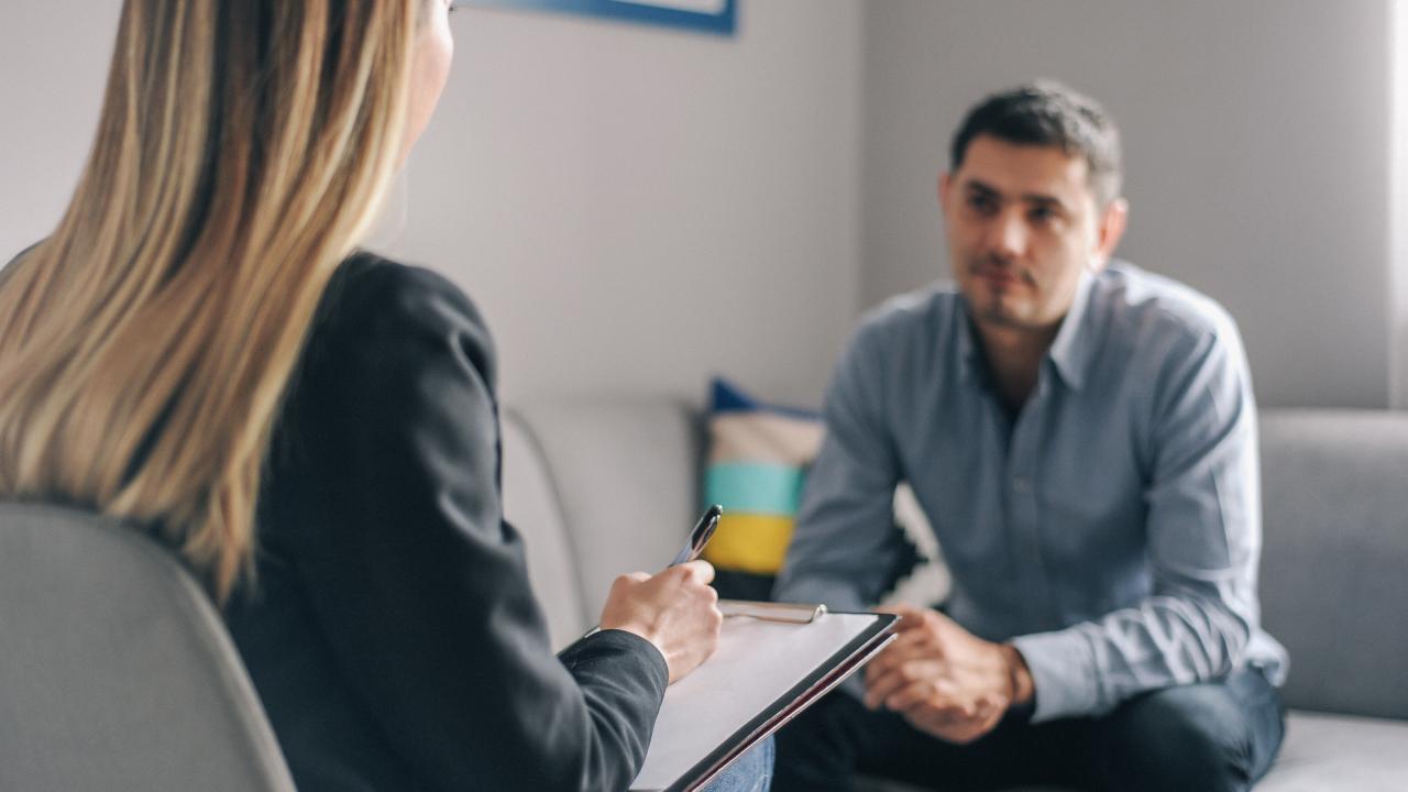 Man speaking with a woman in a living room