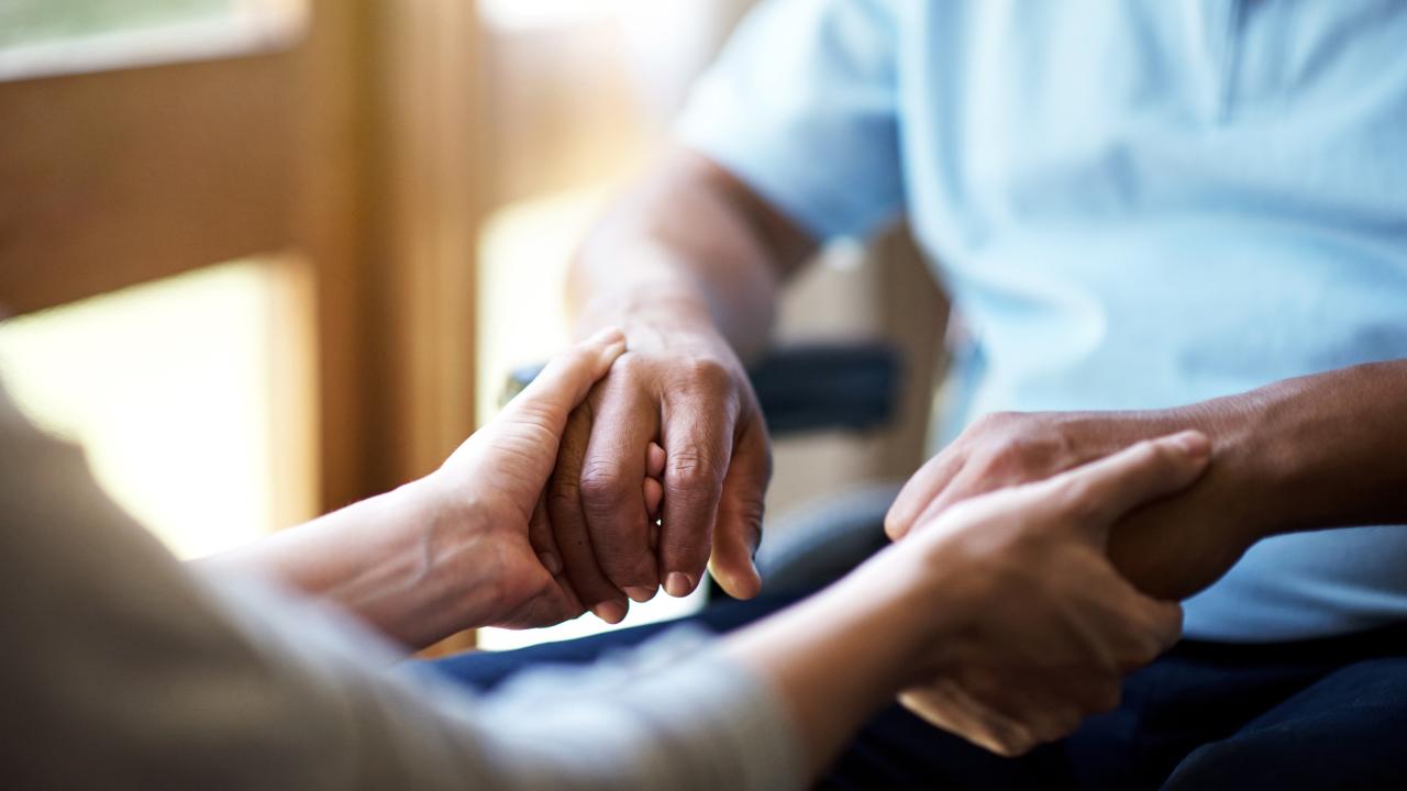 Nurse holding elderly hands