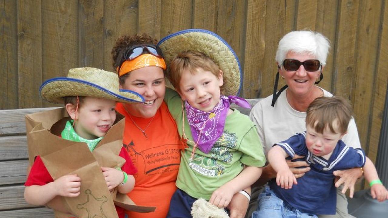 Volunteers with children at a day camp sitting on a bench