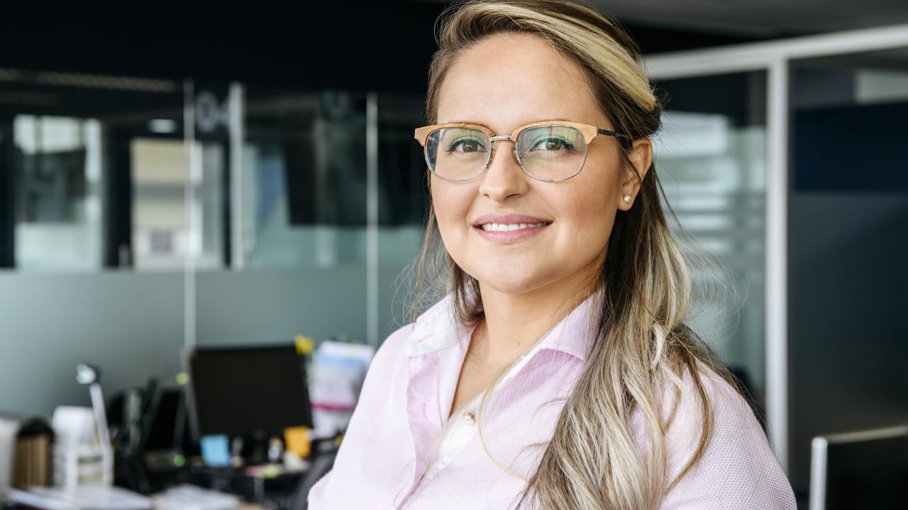 Professional woman standing in an office smiling at the camera