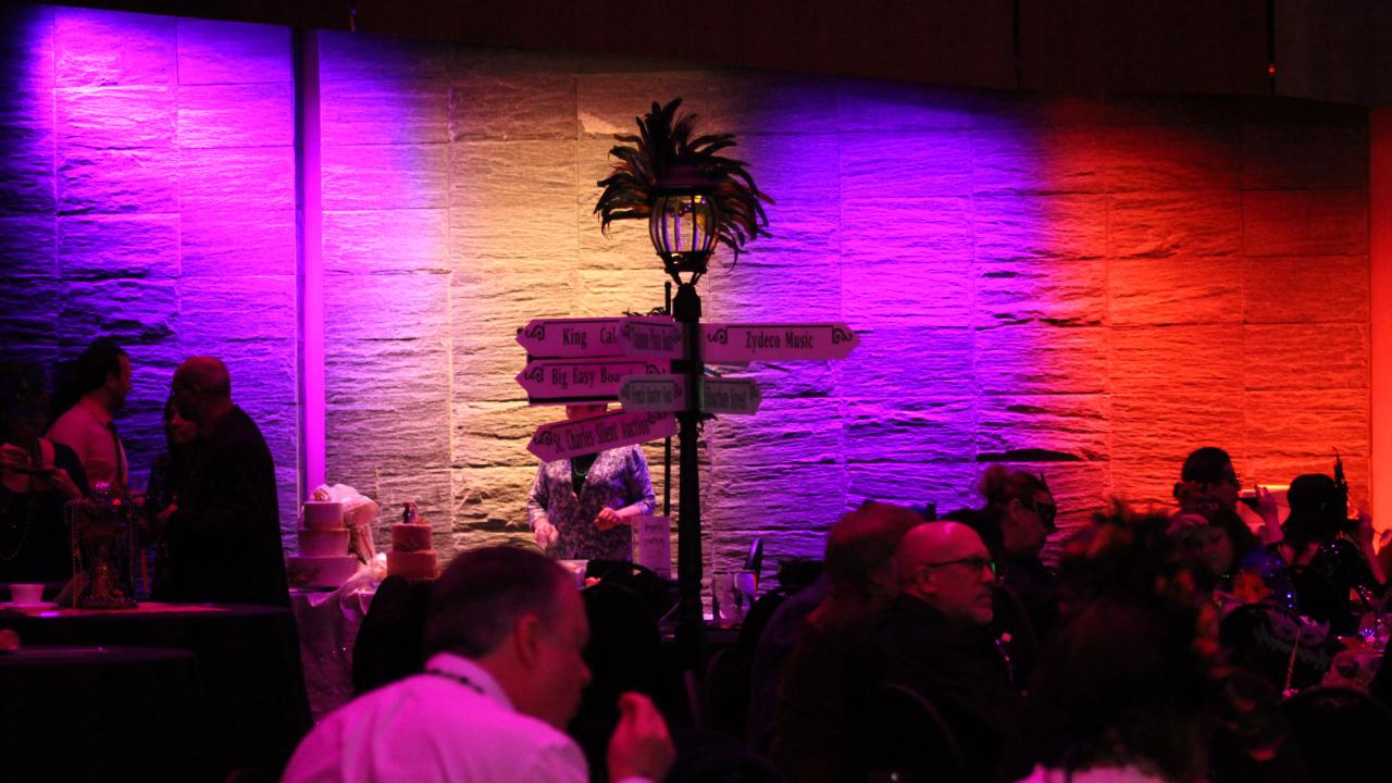Colorful lights and a street sign inside the Corning Museum of Glass during Mardi Gras Gala