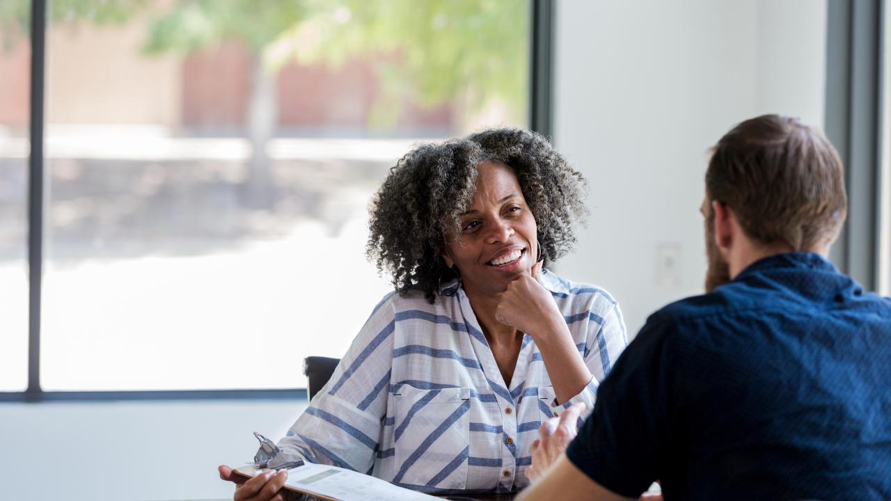 female counselor speaking with an adult male patient