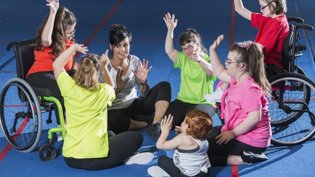 A group of young women with intellectual and developmental disabilities exercising in a gym