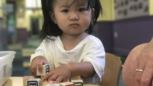 A little girl playing with blocks