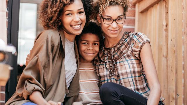 same sex couple hugging a little boy