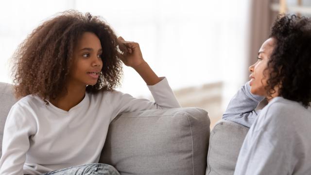 Young girl talking with a woman on the couch